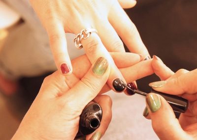 Nail technician applying polish during a manicure