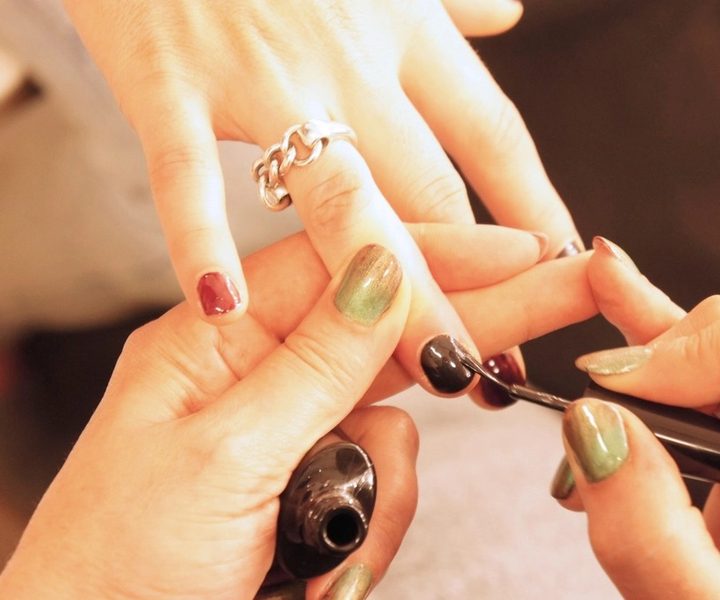 Nail technician applying polish during a manicure