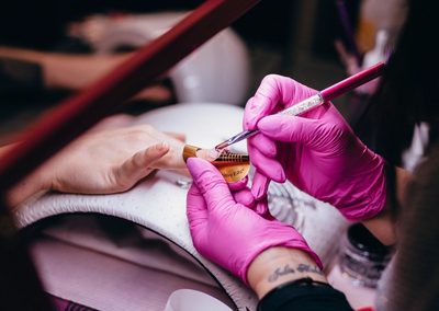 Nail artist painting a custom nail art design